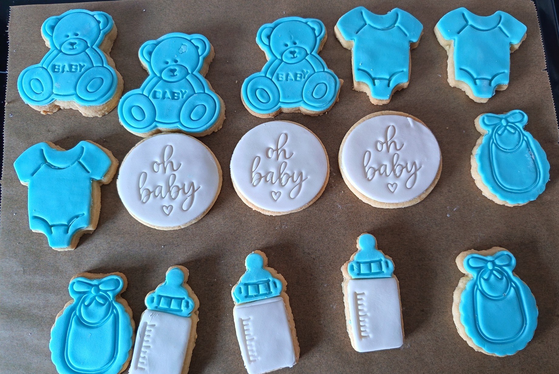 Blue baby shower cookies in teddy and bottle shapes