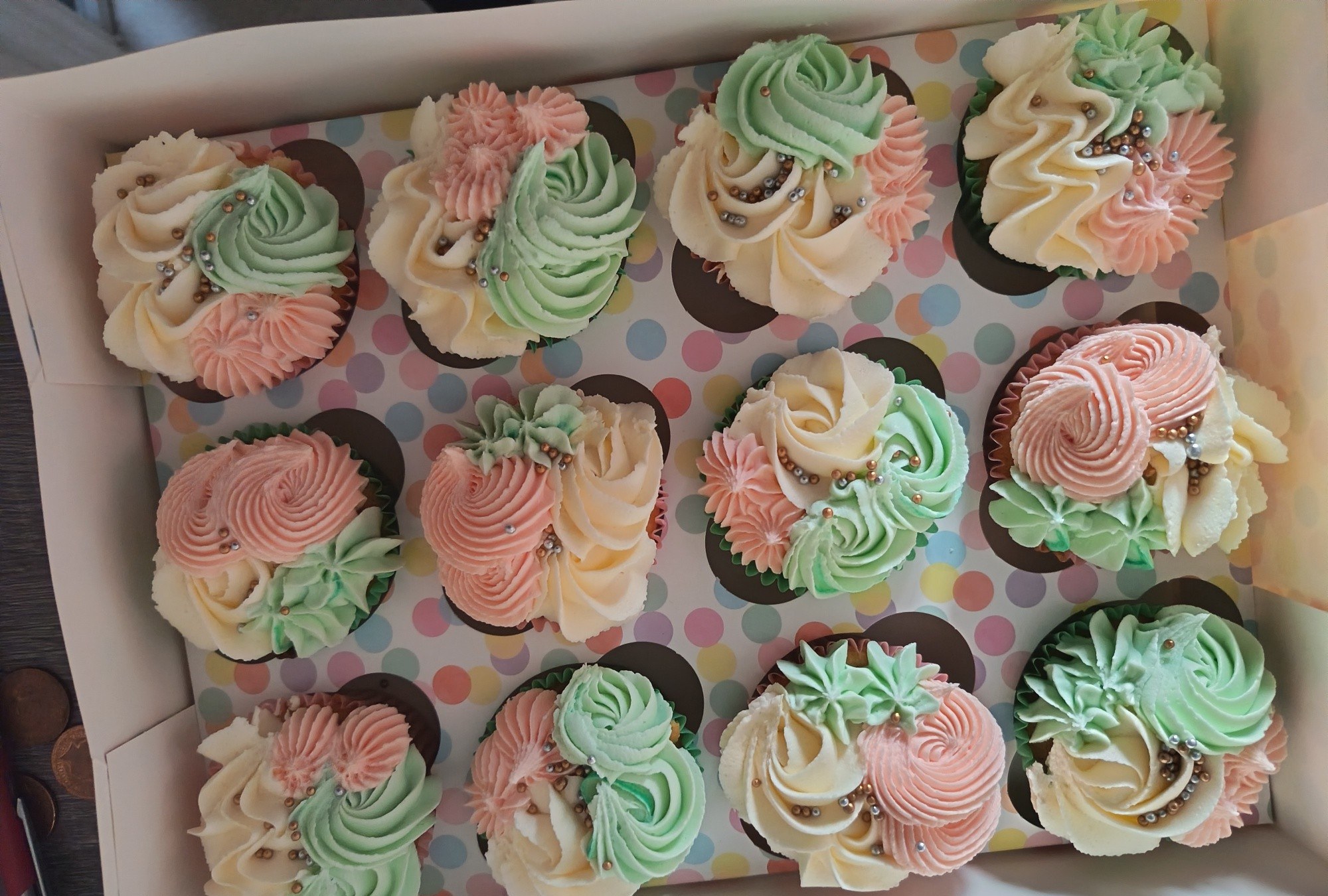 A box of pastel swirl cupcakes in pink, mint and cream
